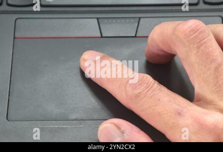 human hand used touchpad of computer laptop for working Stock Photo
