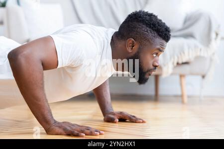 Young black man doing push ups, side view Stock Photo