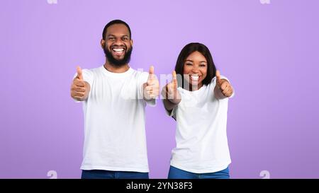 Happy black couple gesturing thumbs up and smiling Stock Photo