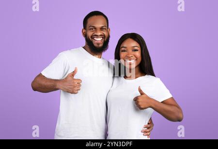 Happyafro couple gesturing thumbs up and smiling Stock Photo