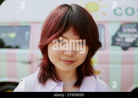 Medium close up of smiling Asian young adult woman looking at camera Stock Photo
