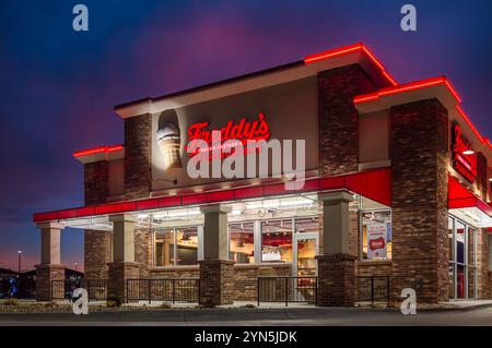 SIOUX FALLS, SD, USA, NOVEMBER 19, 2024:  Freddy's Frozen Custard and Steakburgers restaurant exterior at dusk and trademark logo. Stock Photo