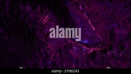 Psychedelic violet. Wet highlights. Fabric texture with iridescent light. Rough purple background with sparkle spots changing color rainbow effect. Stock Photo