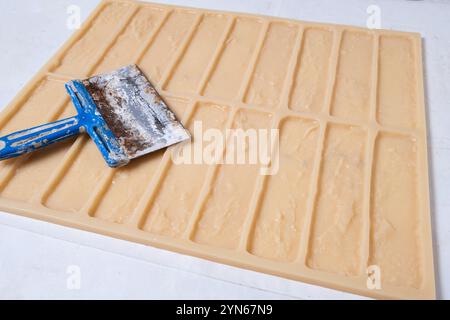 Spatula on background mold for making decorative brick blanks for wall decoration Stock Photo