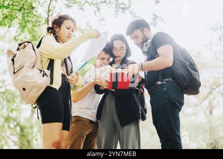 Multicultural students collaborating on school assignments in the park outdoors Stock Photo