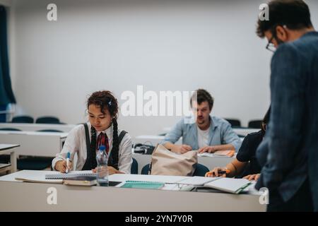 Students engaged in learning with professor assisting during class Stock Photo