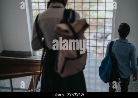 Two students walking down a school staircase with backpacks Stock Photo