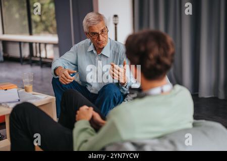 Professor engaging with students in a thoughtful discussion Stock Photo