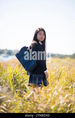 girl in high school uniform smiling while receiving mobile call Stock ...