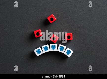 Red dice showing bombs falling on blue dice showing shields, representing protection and barrier against threats. Safety and security concept. Stock Photo