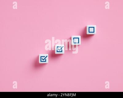 Work or task progression in project management. Completing tasks. White cubes showing increasing progress towards a goal, represented by checkmarks on Stock Photo