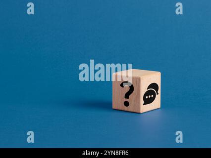 Wooden cube showing question mark and speech bubble representing asking questions, communication, and seeking answers. Q&A questions and answers conce Stock Photo