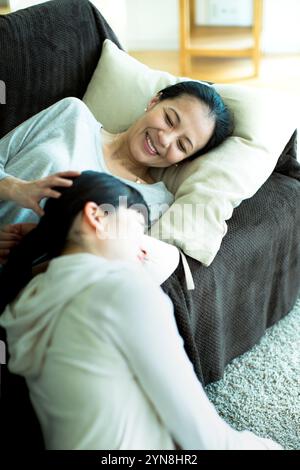 Mother and daughter relaxing on sofa Stock Photo