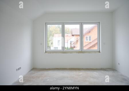 Empty room in new apartment with concrete floor, white walls, and large window. Renovation concept Stock Photo