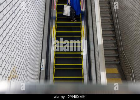 Person on Escalator in Subway Station Stock Photo