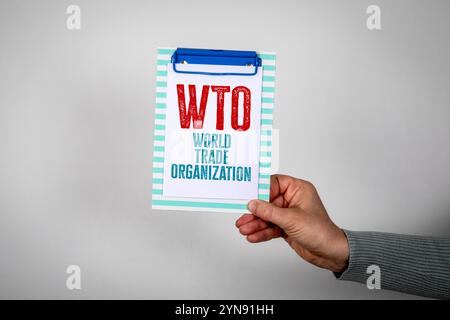 WTO World Trade Organization. In hand note paper with text on a white background. Stock Photo