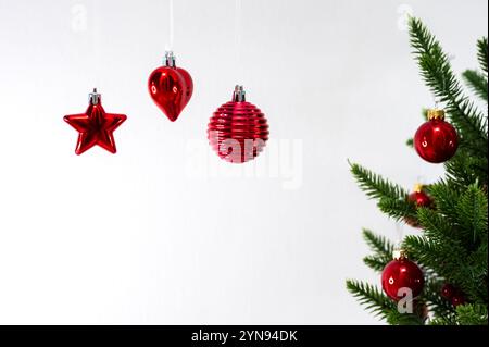 Hanging Christmas ornaments with Christmas tree on white background. Stock Photo
