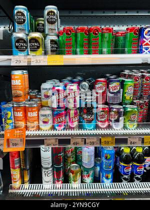 Kyiv, Ukraine - November 24, 2024: An array of various beverage cans including soda, tonic water, and energy drinks displayed on a supermarket shelf. Stock Photo