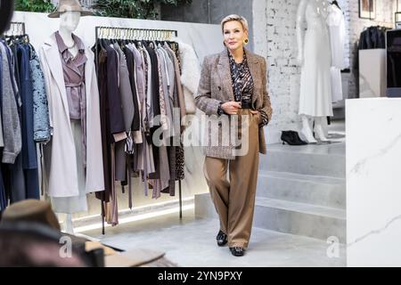 Stylish Mature Woman in Fashionable Clothing Business Outfit With Beige Trousers And Brown Tweed Blazer Standing in female Clothing Store, Owner of Bo Stock Photo