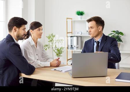 Business people or coworkers sitting at desk, discussing work project, having a meeting in office. Stock Photo