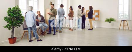 Company employees working on their workplace in the office discussing job and work projects. Stock Photo