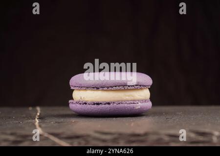 Premium macarons with a purple cream filling, presented on a black background. An image of elegance in food photography Stock Photo