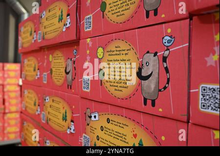 Hamburg, Germany. 25th Nov, 2024. Several red and yellow packages with a message and a cartoon motif are stacked in the Center for Social Logistics. The city pact '#HamburgKyiv' wants to send 4,000 'Love in a box' Christmas parcels for children with toys, clothes, hygiene articles and other everyday items to Kiev for Christmas with the support of the city, companies and charitable associations. Credit: Niklas Graeber/dpa/Alamy Live News Stock Photo