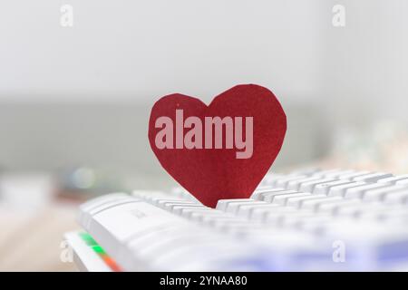 Red paper heart on computer keyboard. Valentine's day love concept. Stock Photo