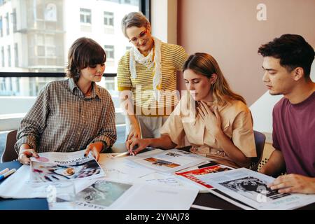 High school students work together on a classroom project, surrounded by city views, fostering teamwork and creativity under their teacher's guidance. Stock Photo