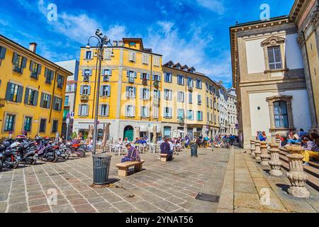 MILAN, ITALY - APRIL 08, 2022: Piazza Sant'Alessandro with groups of students, having lunch on the stairs and benches, on April 8 in Milan, Italy Stock Photo