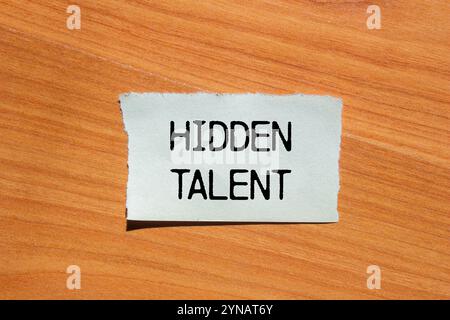 Hidden talent message written on ripped torn paper piece with wooden background. Conceptual hidden talent symbol. Copy space. Stock Photo