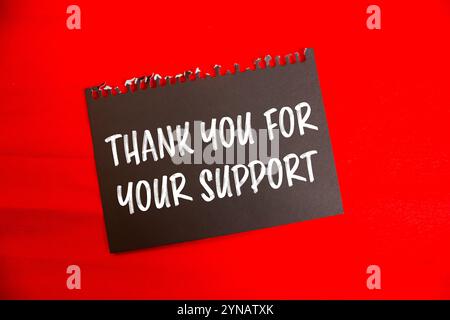 Thank you for your support message written on black paper with red background. Conceptual thank you for your support symbol. Copy space. Stock Photo