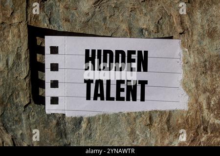 Hidden talent message written on ripped torn paper piece with stone background. Conceptual hidden talent symbol. Copy space. Stock Photo