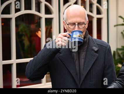 Hamburg, Germany. 25th Nov, 2024. Peter Tschentscher (SPD), First Mayor and President of the Senate of the Free and Hanseatic City of Hamburg, takes a sip from a cup of mulled wine at a press event to mark the opening of the Christmas market. The Christmas market on Hamburg's Rathausmarkt was officially opened on Monday. Credit: Niklas Graeber/dpa/Alamy Live News Stock Photo