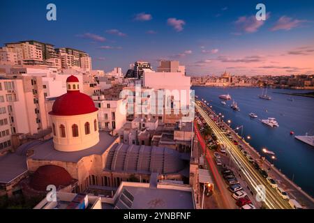 Sliema, Malta. Cityscape image of Sliema, Malta with historical old town of Valletta in the background at beautiful sunset. Stock Photo
