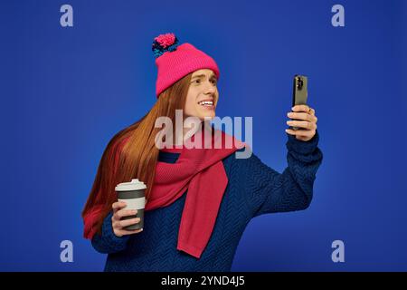 Emotional young man in a vibrant setting shares happiness while taking a selfie. Stock Photo