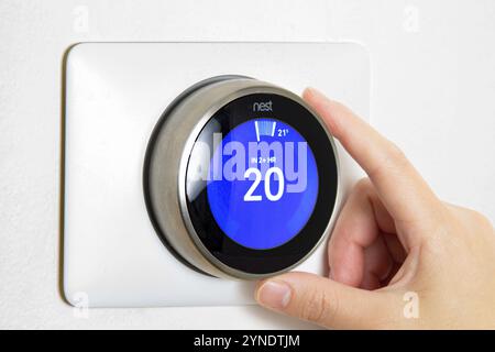 Calgary, Alberta, Canada. Jun 5, 2020. A person cooling down Home Air Conditioning, temperature is on centigrade celsius metrics using a Nest smart th Stock Photo