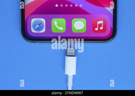 Calgary, Alberta, Canada. Nov. 19, 2020. An iPhone Pro with a Lightning to USB Cable on a blue background Stock Photo
