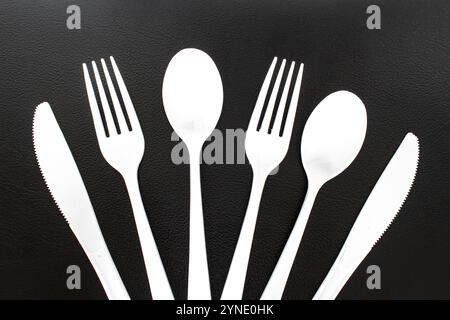 Single use white plastic cutlery on a leather background. Concept: Ban single use plastic Stock Photo