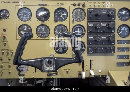 Calgary, Alberta, Canada. Aug 5, 2024. A detailed view of a flight simulator cockpit, featuring a yoke, an array of gauges, and various control panels Stock Photo