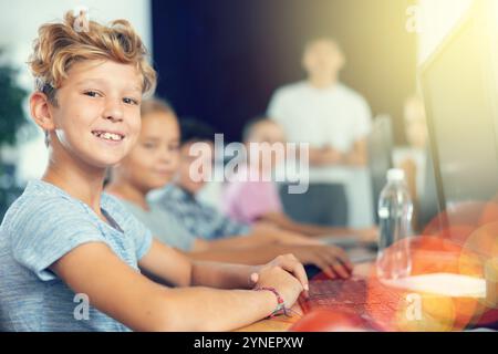 Focused teenager studying with classmates in school classroom Stock Photo