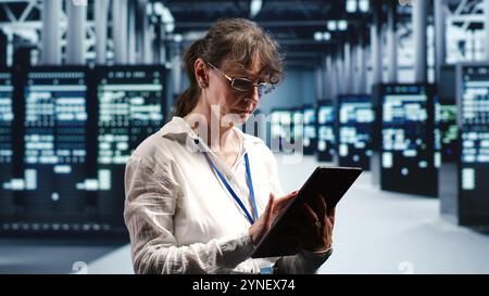 Senior programmer working in data center housing GPU dedicated server cabinets that can process artificial intelligence tasks with high efficiency, fixing defective machines used for machine learning Stock Photo