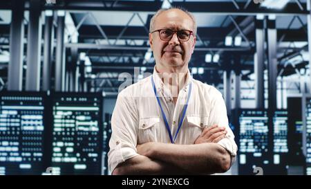 Portrait of senior technician looking around modern server hub in data center, preparing to start comission on malfunctioning high tech workplace hardware racks in order to ensure flawless operations Stock Photo