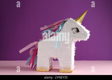 Bright pinata in shape of unicorn on color background Stock Photo