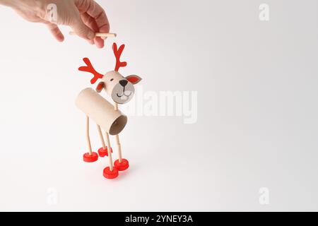 DIY reindeer puppet made from cardboard tubes, plastic caps, and paper. Studio shot on white background. Christmas craft and holiday decoration concep Stock Photo