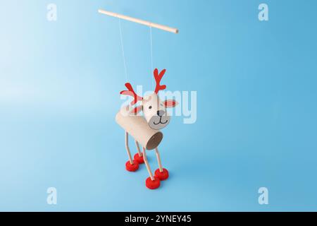 DIY reindeer puppet made from cardboard tubes, red bottle caps, and paper details. Christmas craft and holiday theme. Easy activity for children. toil Stock Photo