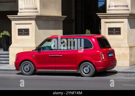 A red taxi waiting at the main entrance of the 5-star Four Seasons Hotel (2012) in Baku, Azerbaijan Stock Photo