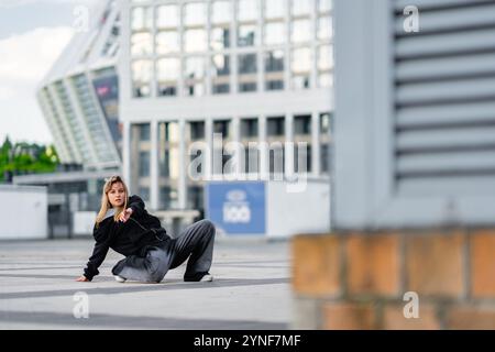 Young dancer showcases urban dance moves in a city environment Stock Photo