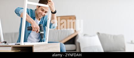 Assembling chipboard furniture using cordless screwdriver at home Stock Photo