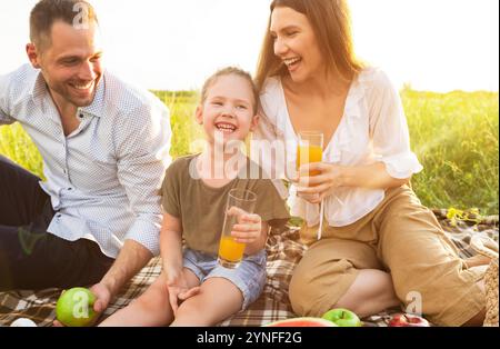 Laughing family drinking orange juice from glasses Stock Photo